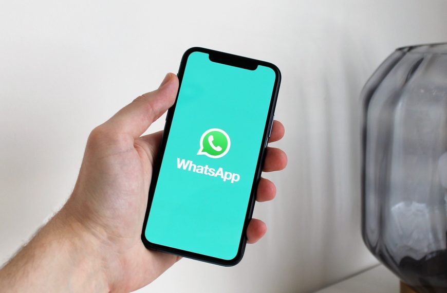 Persona sosteniendo un teléfono móvil con la aplicación WhatsApp abierta en la pantalla.