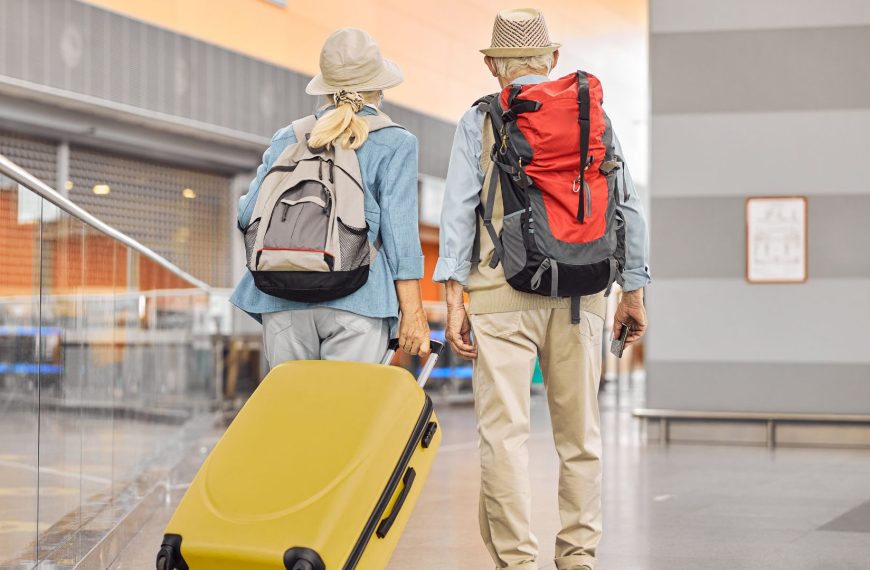 Two Caucasian elderly travelers standing at the airport - Fotos de Canva