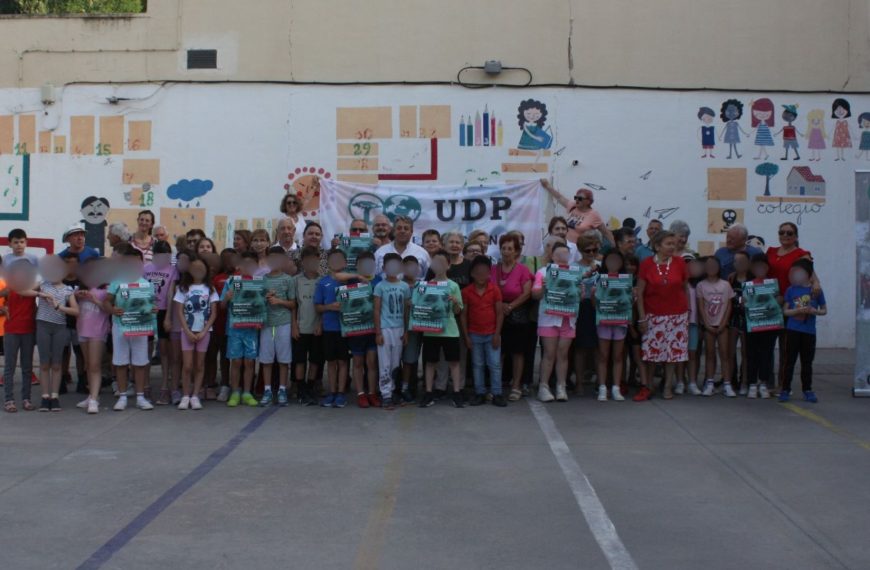 Grupo de personas mayores posando sonrientes con niños y niñas durante una actividad al aire libre organizada por UDP el 15 de junio de 2025